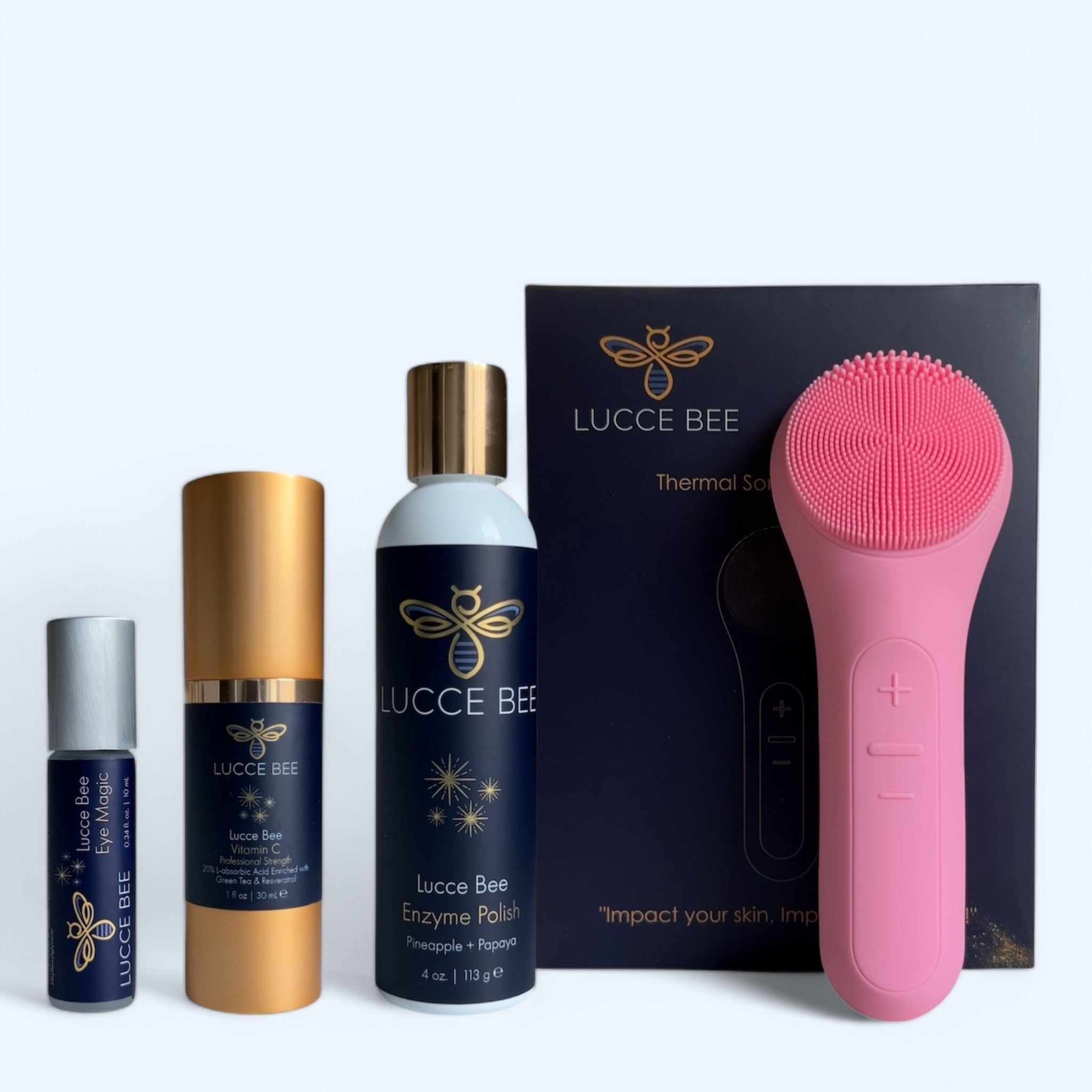 Lucce Bee skincare set featuring Eye Magic, Vitamin C Serum, Enzyme Polish, and pink silicone cleansing brush. Curated facial care essentials for anti-aging, exfoliation, hydration, and spa-like at-home skincare routines. Reveal radiant, healthy skin.