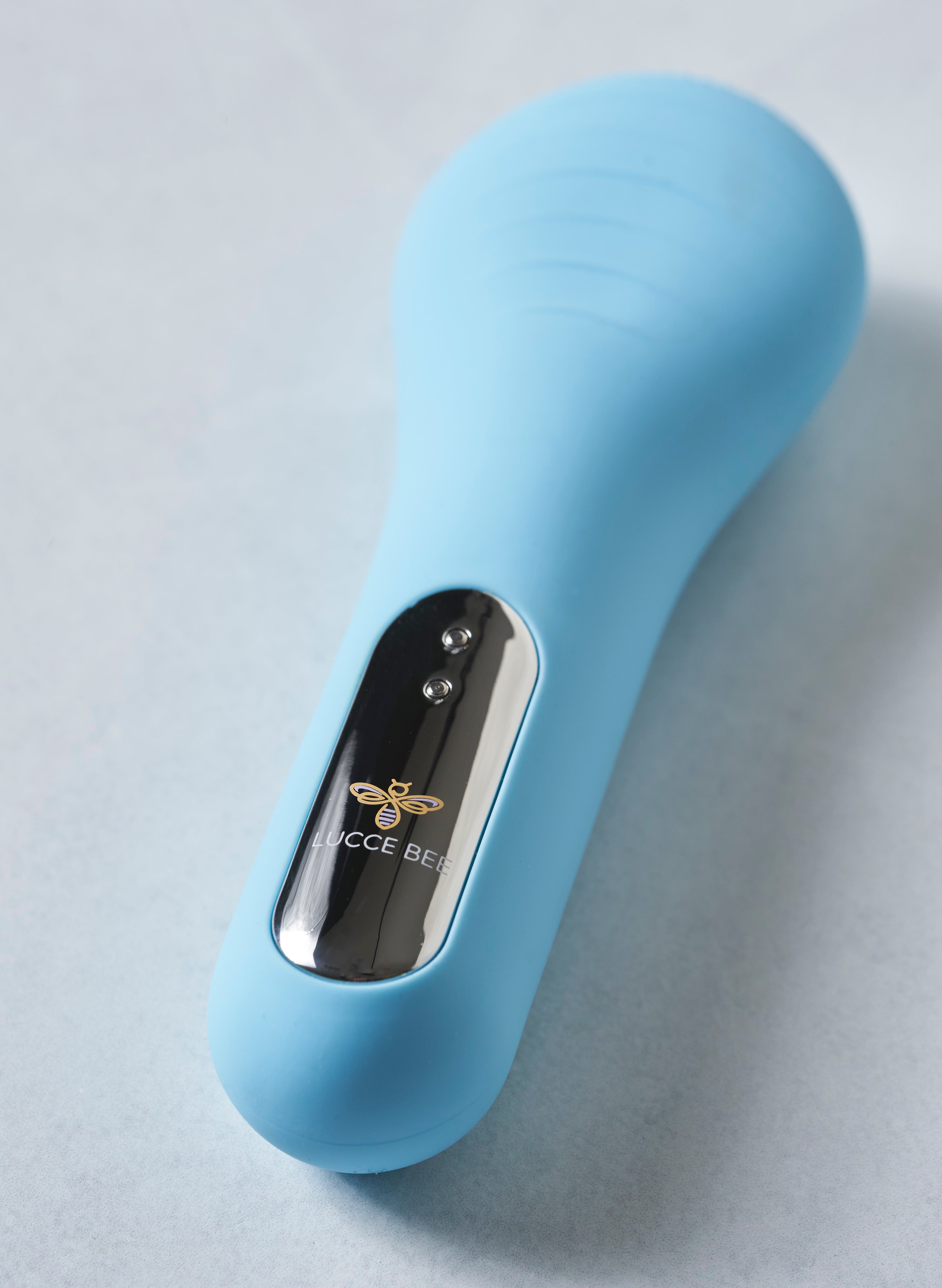 Close-Up of Lucce Bee Blue Sonic Facial Brush – Waterproof Silicone Skincare Tool with Sleek Metallic Accent and Brand Logo