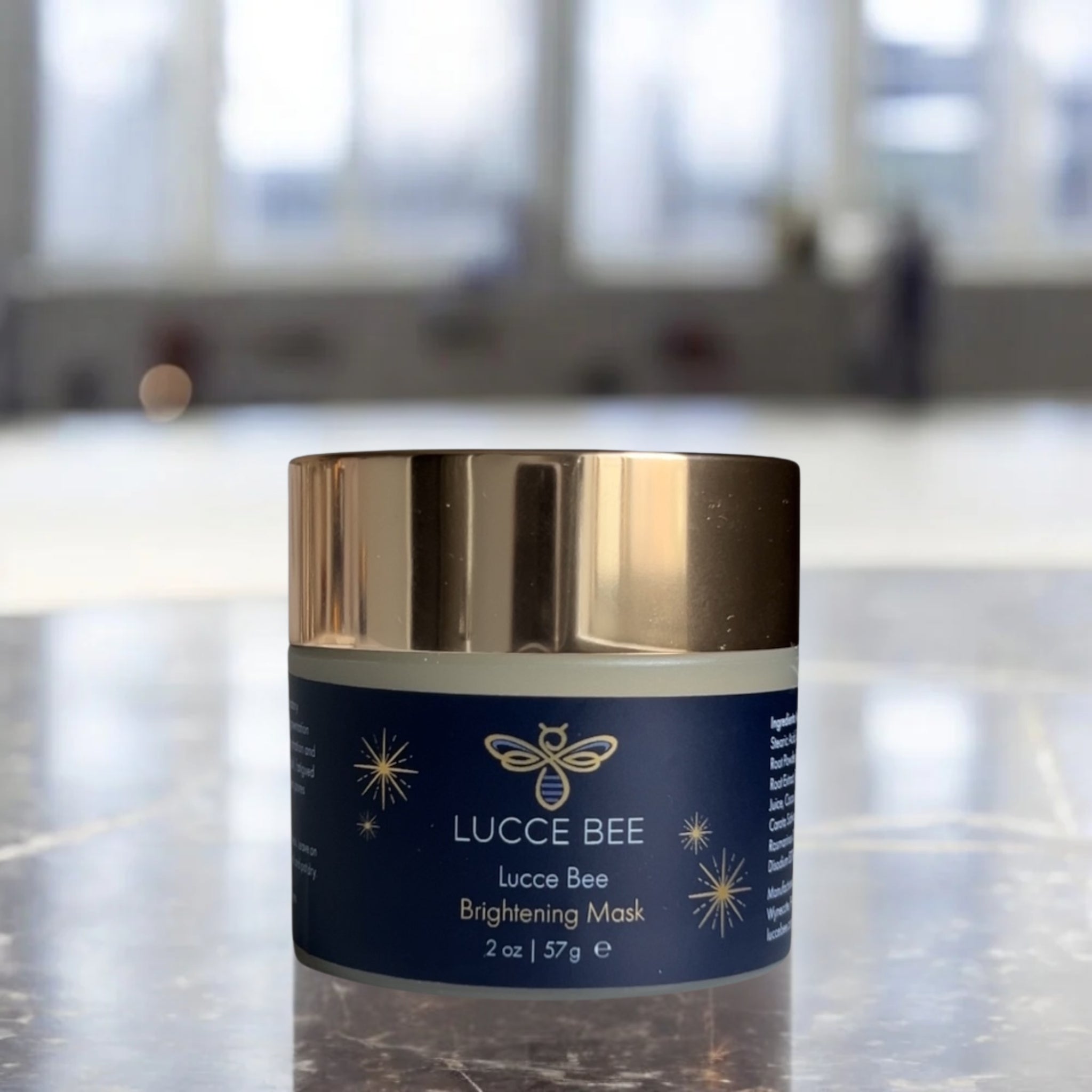 Lucce Bee Brightening Mask – Luxury Skincare Jar with Gold Lid for Radiant, Even-Toned Skin Displayed on Marble Surface (2 oz)