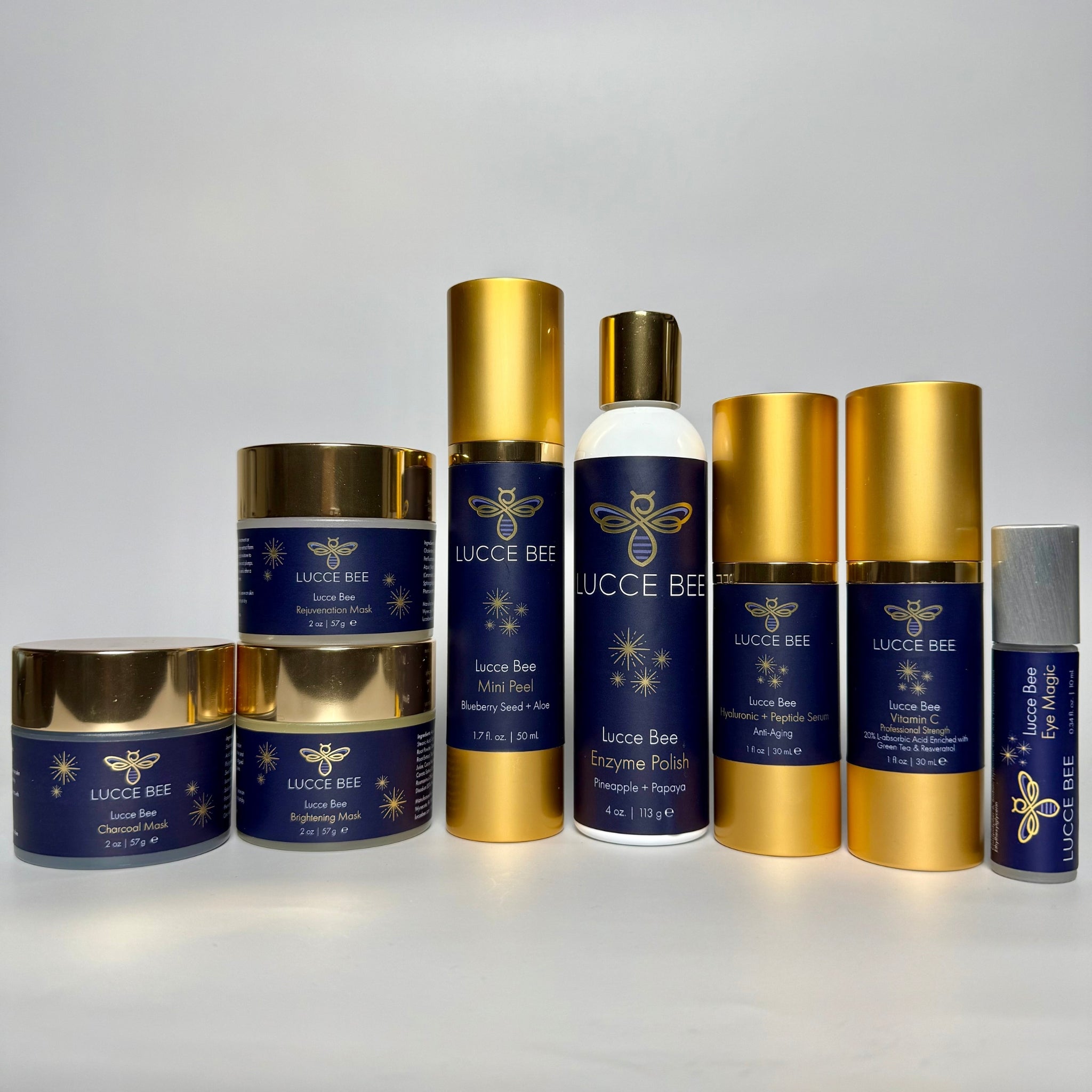 Lucce Bee skincare products featuring Vitamin C Serum, Hyaluronic + Peptide Serum, Enzyme Polish with pineapple and papaya, and Eye Magic. Clinical luxury skincare essentials for brightening, anti-aging, hydration, exfoliation, and under-eye care.